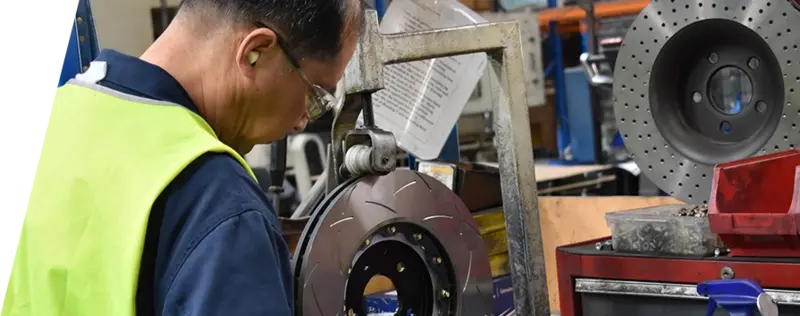 Tecnico dello stabilimento DBA con dispositivi di sicurezza al lavoro sulla produzione di dischi freno con attrezzature specializzate nell'impianto produttivo