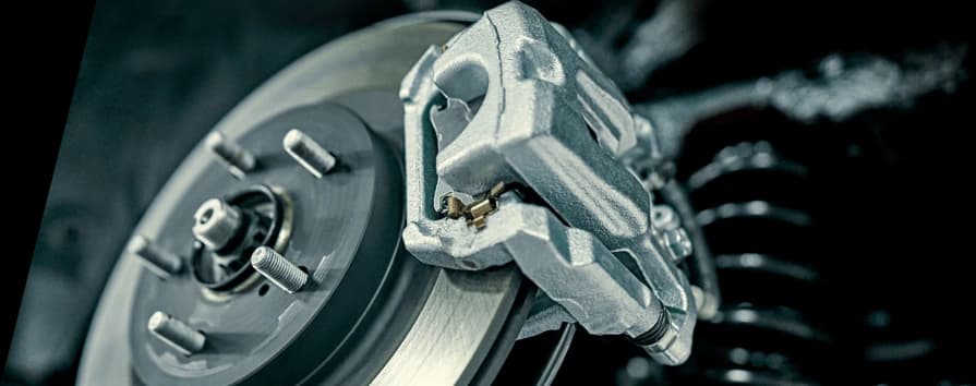 Gruppo pinza freno montato sul disco freno che dimostra un'installazione professionale dell'impianto frenante e l'integrazione dei componenti Pinza freno argentata montata sul disco freno che mostra un'installazione professionale e componenti di frenata prestazionali