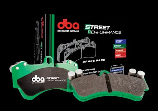 Pastiglie freno DBA Street Performance progettate per prestazioni potenziate in auto, SUV e 4x4 Pastiglie freno DBA Street Performance con piattelli metallici verdi e materiale d'attrito mostrate accanto alla confezione di vendita