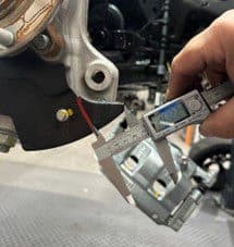 Passo 2D: Misurazione della distanza del taglio di gioco inferiore di circa 41 mm dal bordo del piatto porta-ceppi per una modifica di precisione Calibro digitale che misura circa 41 mm dal bordo del piatto porta-ceppi per il taglio di gioco inferiore durante l'installazione dell'upgrade freni DBA