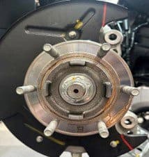 Passo 2B: Contrassegni dei tagli di gioco completati sul piatto porta-ceppi che mostrano le aree di modifica precise per l'upgrade della pinza DBA Piatto porta-ceppi con contrassegni a pennarello completati che mostra dove il materiale deve essere rimosso per il corretto montaggio della pinza DBA a 6 pistoni