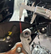 Passo 2C: Misurazione della distanza del taglio di gioco superiore di circa 40 mm dal bordo del piatto porta-ceppi per una modifica di precisione Calibro digitale che misura circa 40 mm dal bordo del piatto porta-ceppi per il taglio di gioco superiore durante l'installazione dell'upgrade freni DBA